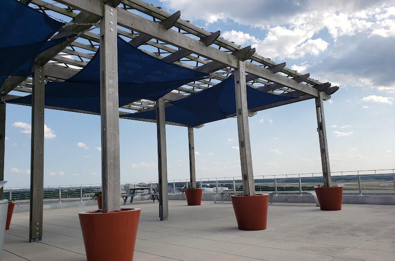 Multi shades sails attached to a pergola to create shade while allowing airflow.